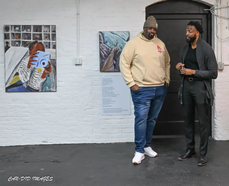 Two guests in conversation in the gallery.