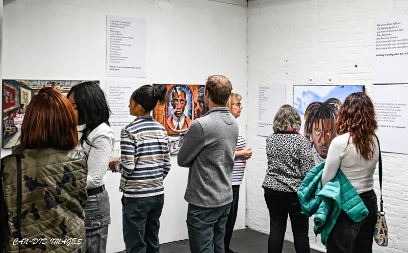 A group gathering around a painting.