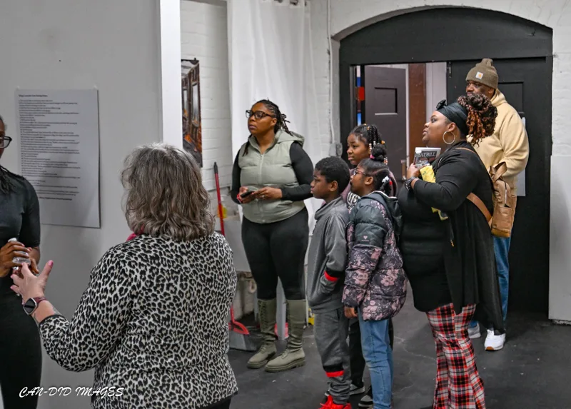 Visitors listening and sharing in the gallery.