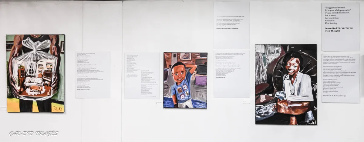 Paintings and accompanying writing displayed on a gallery wall.